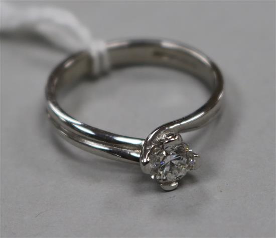 A modern 18ct white gold and twist claw set solitaire diamond ring, size M.